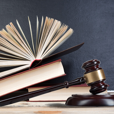 Open law books stacked beside a judge's gavel