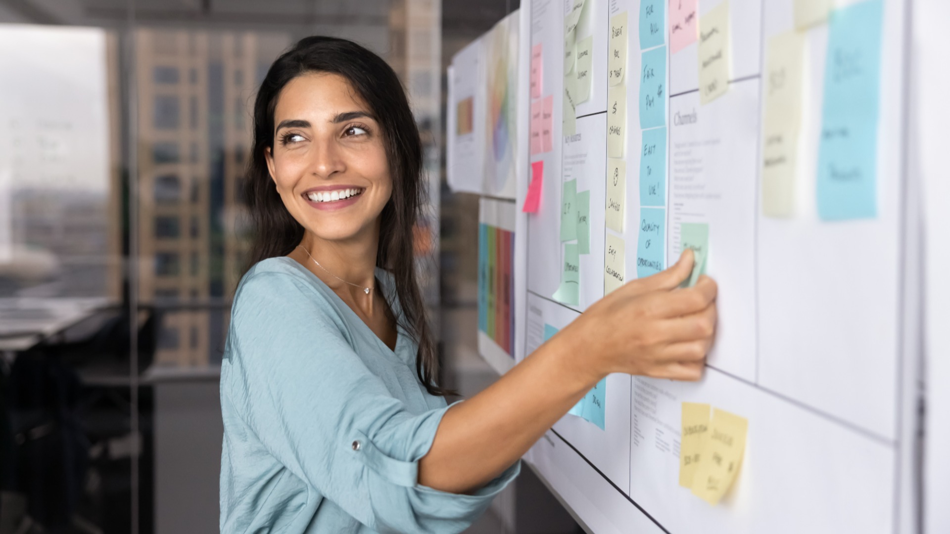 Marketing manager arranging sticky notes on a campaign planning board