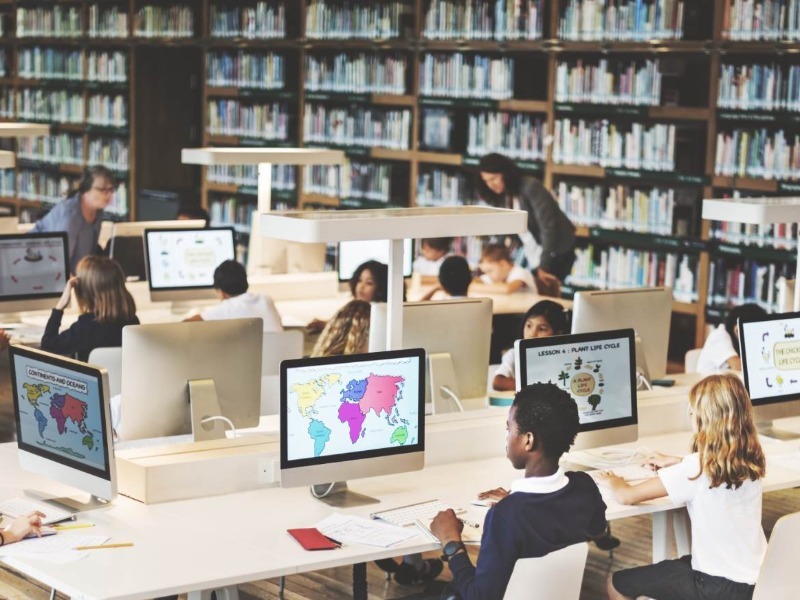 Students work at computers in a school library