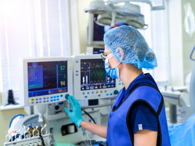 Anesthesiologist checking vital-sign monitors in an operating room