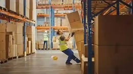 Worker moving boxes in warehouse