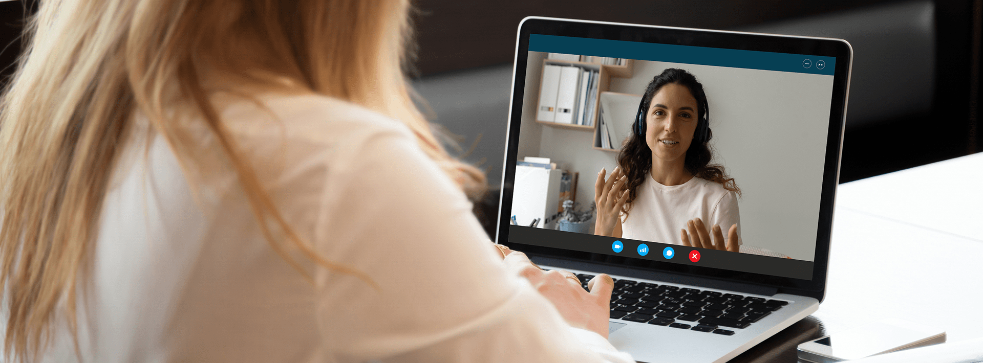 Person on a laptop video call with an interpreter wearing a headset