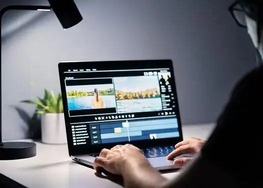A person editing video footage on a laptop