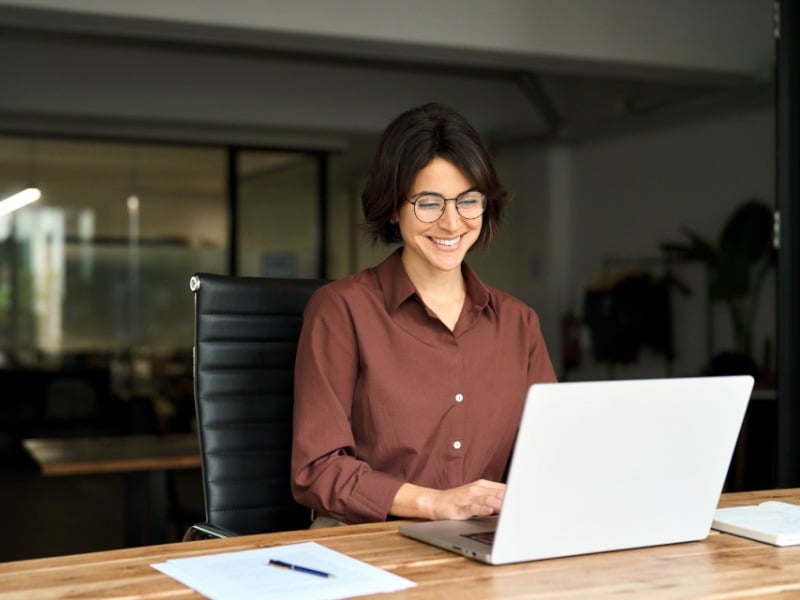 Smiling businesswoman working on a laptop in a modern office