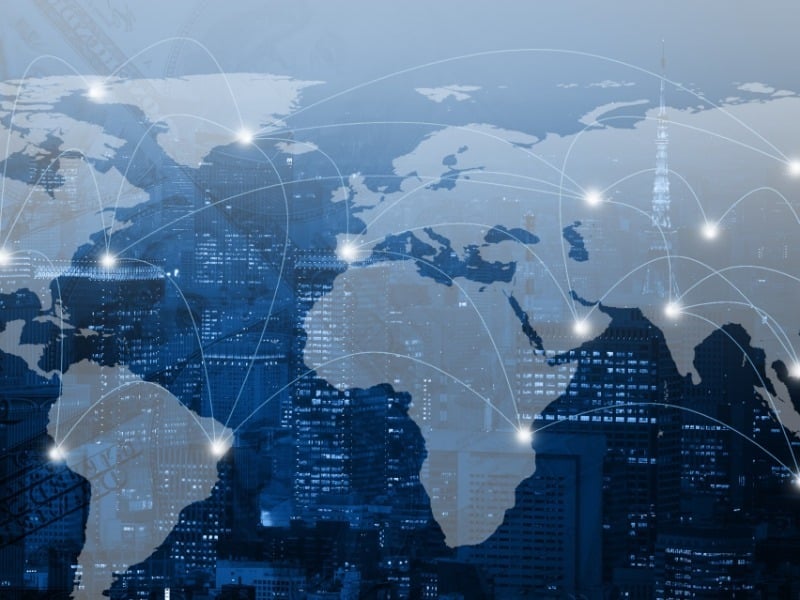 World map with connected network lines over a city skyline